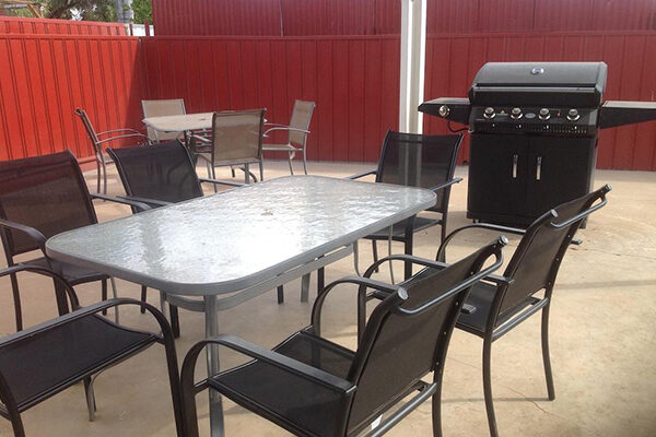 Outdoor entertainment area and BBQ overlooking the pool and gardens of in the Copper Gate Motel, Mt Isa, QLD