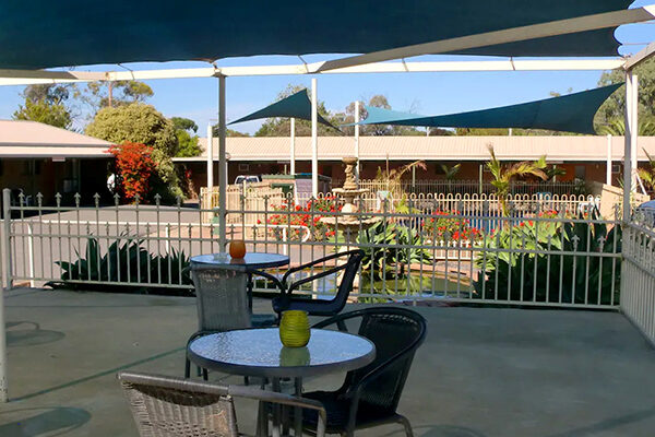 Outdoor dining overlooking the fountain and pond, and swimming pool at the Tooleybuc Motel, NSW